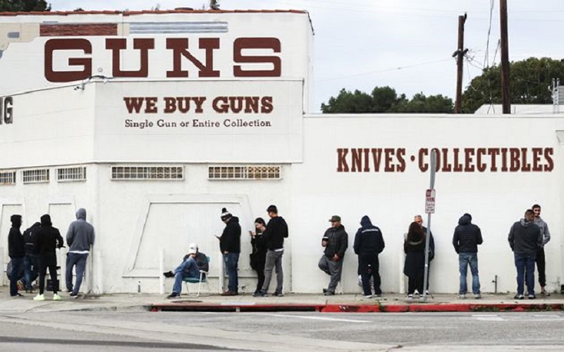 En pleine pandémie de coronavirus aux  États-Unis, des  citoyens font la queue pour acheter des armes
