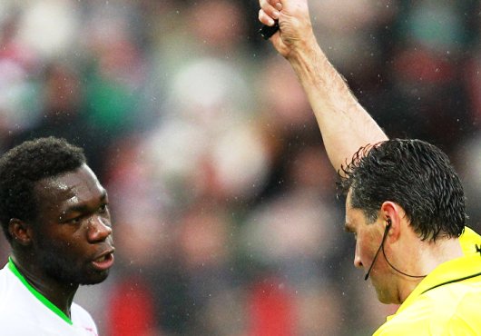 Un arbitre de football sort un carton vert. Une première